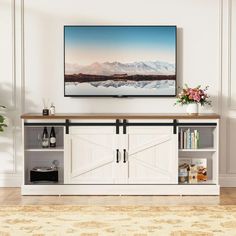 a flat screen tv mounted to the side of a white entertainment center with sliding doors