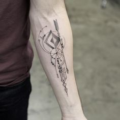 a man with a tattoo on his arm is holding something in his hand and looking at the camera