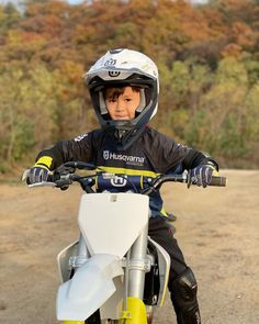 a young boy sitting on top of a dirt bike