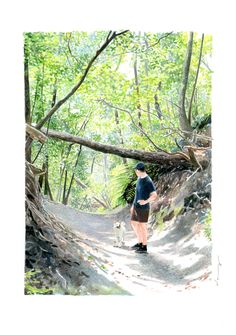 a woman walking her dog down a path in the woods