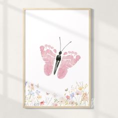 a pink butterfly print hanging on a wall