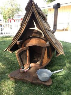 a wooden stove sitting on top of a lush green field