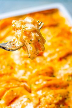 a fork with some food on it in a casserole dish that is ready to be eaten