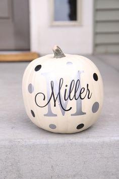 a white pumpkin with black polka dots and the word miller painted on it's side