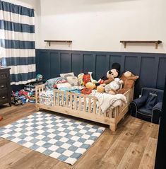 a child's bedroom with blue and white striped walls, wood flooring and teddy bears in the crib