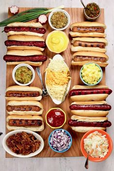 hot dogs and condiments are laid out on a cutting board to be served