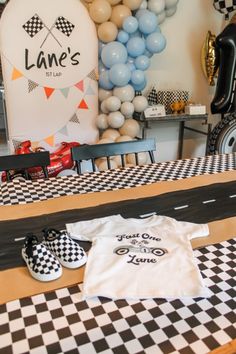 a black and white checkered table with balloons, t - shirt and slippers