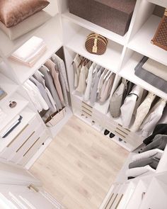 an overhead view of a closet with white shelves and clothes hanging on the wall,