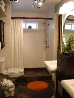 a bathroom with a toilet, sink and shower