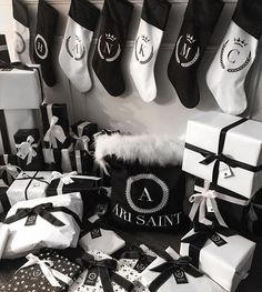 black and white christmas stockings, gift bags, and other holiday gifts are on the floor