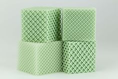 four pieces of green mesh sitting next to each other on a white surface with no background