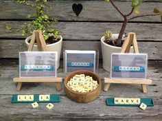 a wooden table topped with lots of different types of letters next to potted plants