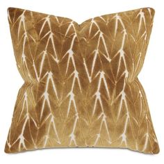 a brown and white pillow with an arrow pattern on the front, sitting on a white background