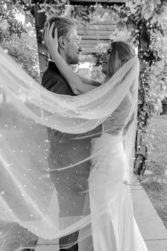 a bride and groom are hugging under the veil