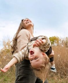 a woman holding a child in the air with her mouth open and eyes wide open