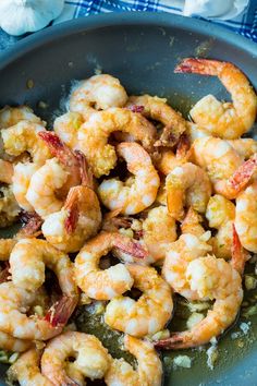 cooked shrimp in a skillet with garlic and pepper on the side, ready to be eaten