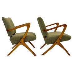 a pair of mid century modern chairs with arms and backrests in green upholstered fabric