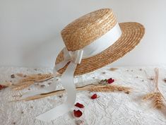 Natural straw boater hat decorated with a taffeta ribbon with double bow at the back. Flat oval-shaped cap. Composition: 100% natural straw, taffeta. Sizes: 54 to 58 cm (head circumference). Dimensions: Diameter: 32 cm approx. (12.6") Crown height: 9 cm approx. (3.5") Edge width: 5 to 7 cm (2 to 2.8") Straw boater hat with a flat, oval crown, very soft and pleasant to wear due to its elasticity. Made with natural straw ribbons, of superior quality, very flexible, sewn by hand with traditional mi Elegant Natural Boater Hat For Garden Party, Short Brim Boater Hat With Ribbon For Garden Party, White Straw Boater Hat With Curved Brim, Cream Boater Hat With Flat Brim For Garden Party, Kentucky Derby Boater Hat With Ribbon For Garden Party, Kentucky Derby Boater Hat With Ribbon, Cream Mini Hats For Summer Ceremonies, Cream Mini Hat For Summer Ceremony, Cream Mini Hat For Summer Ceremonies