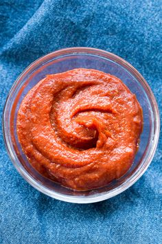 a bowl filled with red sauce on top of a blue cloth