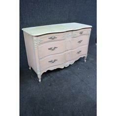 an antique dresser with white paint and drawers