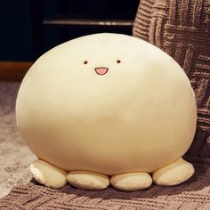 a white stuffed animal sitting on top of a carpet