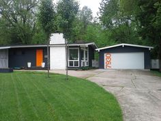 a house that is in the middle of a yard with grass and trees around it