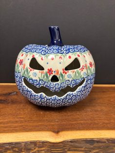 a painted pumpkin sitting on top of a wooden table