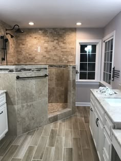 a bathroom with tile flooring and white cabinets