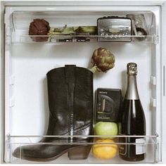 an open refrigerator filled with assorted items including wine, fruit and veggies