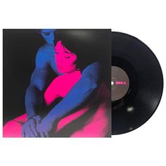 a black vinyl record with pink and blue images on it