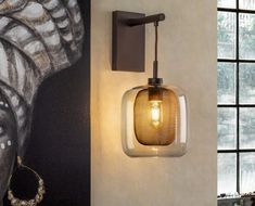 a wall mounted light next to a painting