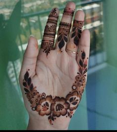 a woman's hand with henna tattoos on it