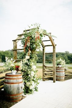 an outdoor ceremony with barrels and flowers