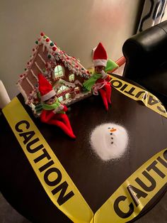 two elfs sitting on top of a table with a caution sign