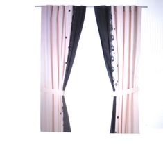 two black and white curtains hanging on the side of a wall