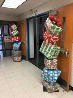 several wrapped presents are stacked on top of each other in front of an open door