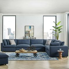 a living room with blue couches and wooden coffee table in front of large windows