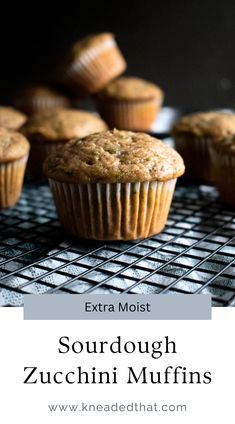 some muffins sitting on top of a cooling rack with the words, extra moist sourdough zucchini muffins