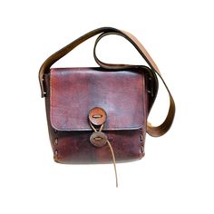 "This amazing bag will last a lifetime! Beautiful thick leather. Hand stitched, very cool leather buttons with wrap around leather string to close the purse.  Perfect for everyday! It sits at the hip with the shoulder strap. Could be worn as a crossbody, the purse will sit just above the hip.  It's approximately 8\"x8\"x2\" It's in great vintage condition, the flap has some pen marks and the bag has a few scuffs.  It's been treated with an organic beeswax leather conditioner." Vintage Leather Bag For Everyday Carry, Vintage Leather Shoulder Bag For Everyday, Leather Shoulder Bag With Snap Closure For Everyday Use, Everyday Leather Shoulder Bag With Snap Closure, Vintage Brown Satchel For Everyday Carry, Leather Satchel With Snap Closure For Daily Use, Brown Vintage Satchel For Everyday Carry, Brown Leather Satchel With Snap Closure, Vintage Leather Bags With Snap Closure