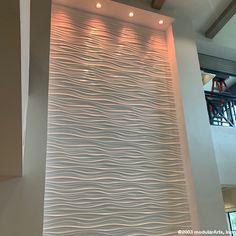 a large white wall with wavy lines on it's side and lights above the top