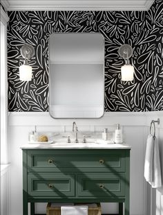 a bathroom vanity with two sinks and a large mirror above it, in front of a patterned wallpaper