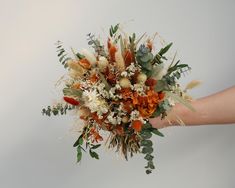 a bouquet of flowers is being held by someone's hand