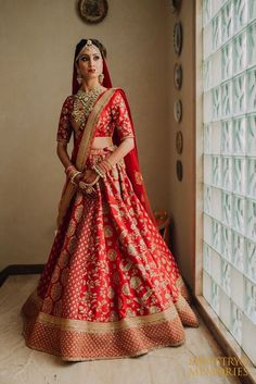 a woman in a red and gold bridal gown