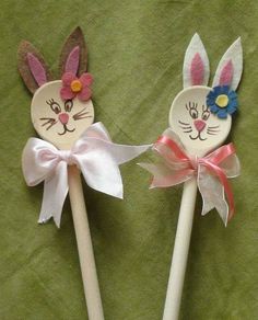 two wooden spoons decorated with bunny ears and flowers