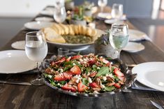 a table is set with plates, silverware and wine glasses for a festive meal