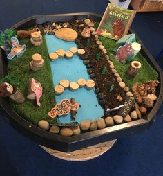 a table topped with lots of fake rocks and plants in a bowl filled with water