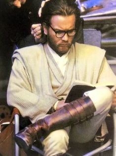 a man sitting on top of a metal chair next to a person with an arm cast