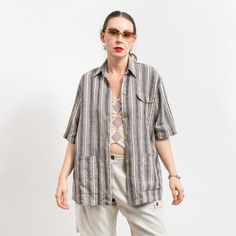 Vintage linen loose fit short sleeve blouse in cream-gray stripes - 3 pockets - fastened with wooden buttons - materials: 100% linen Size from the label: 40 best fits women: L/XL MEASUREMENTS bust: 48 inches (122 cm) length: 30 inches (76 cm) The model is 5'9" (174 cm), measures 35-27-38 (89-69-96 cm) and typically wears clothing in size M CONDITION - 9/10 - The shirt in great pre-owned condition. Washed, ready to wear Striped Short Sleeve Shirt With Pockets, Summer Blouse With Vertical Stripes And Relaxed Fit, Striped Linen Short Sleeve Top, Beige Tops With Vertical Stripes For Summer, Striped Relaxed Fit Short Sleeve Blouse, Oversized Striped Short Sleeve Blouse, Striped Short Sleeve Blouse With Relaxed Fit, Striped Blouse With Pockets Relaxed Fit, Striped Short