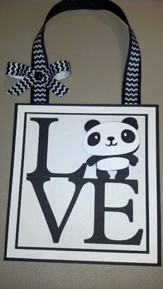 a black and white bag with a panda bear on it's back hanging from the wall