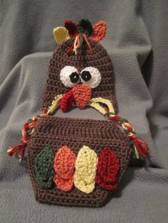 two crocheted turkey hats on top of each other, one with eyes and ears